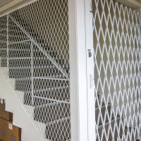 Металлическая решетчатая дверь на лестнице