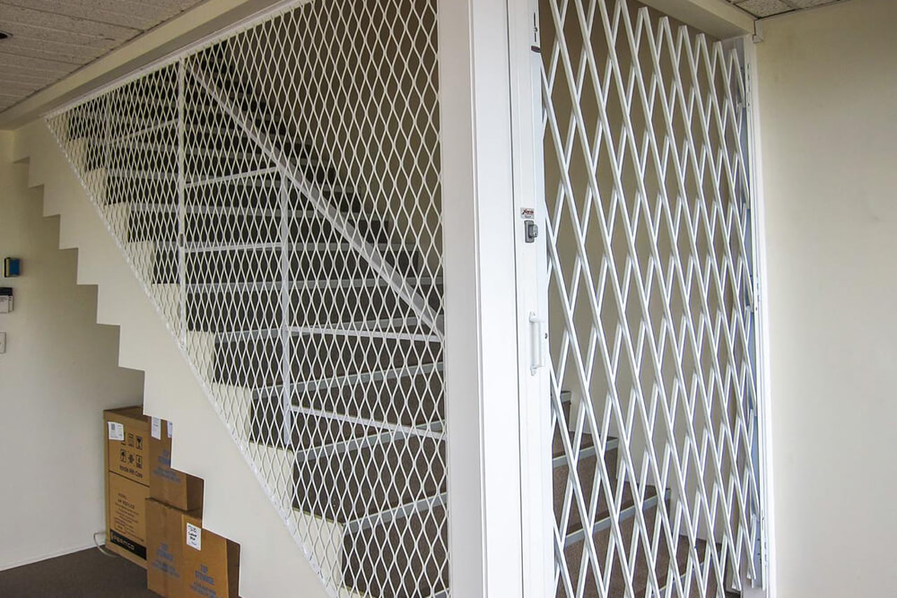 Металлическая решетчатая дверь на лестнице