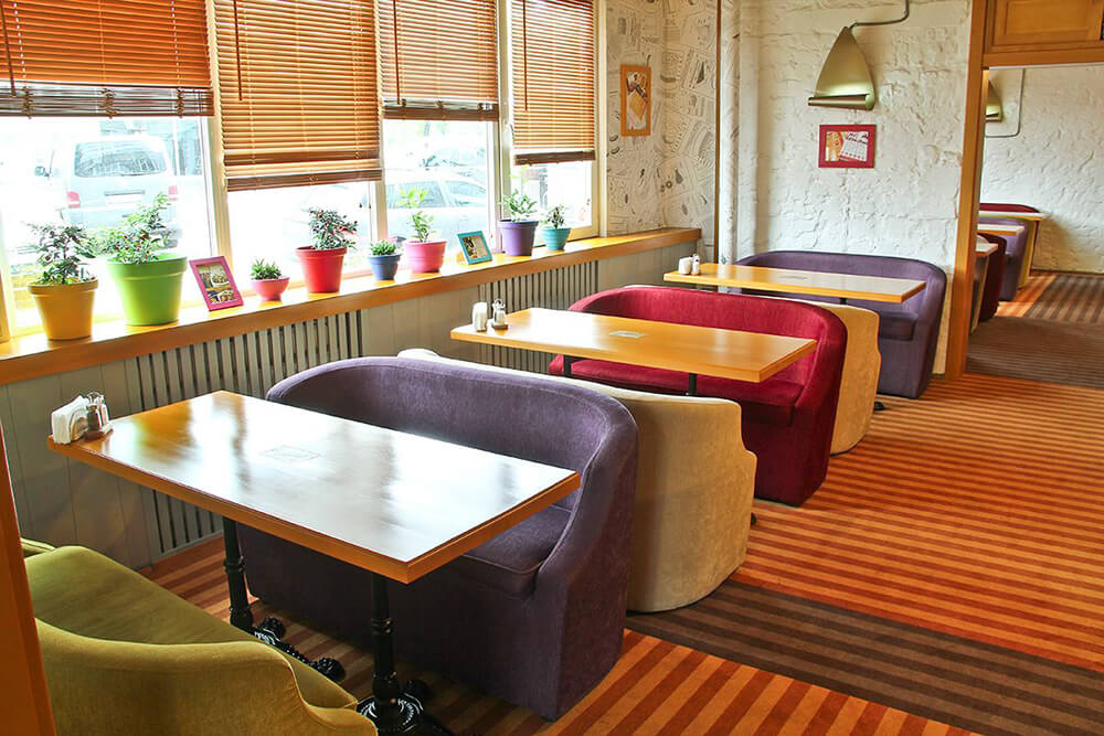 Прямоугольные столы с диванами в кафе